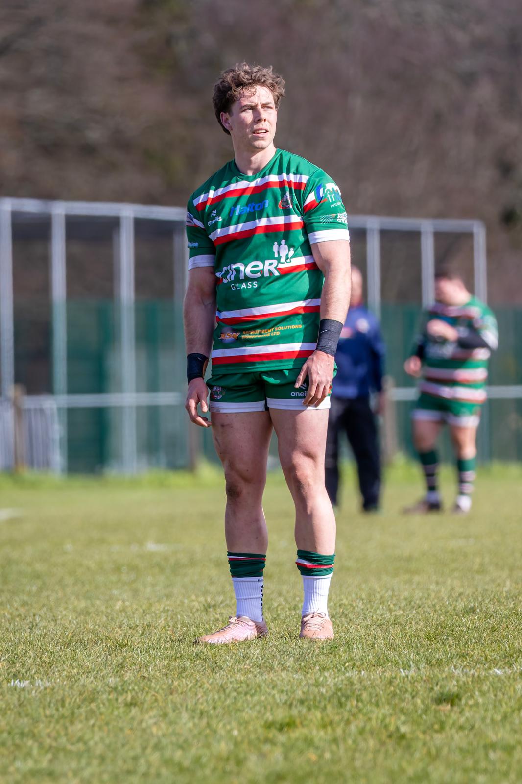 Tom Price standing on the field in green rugby kit